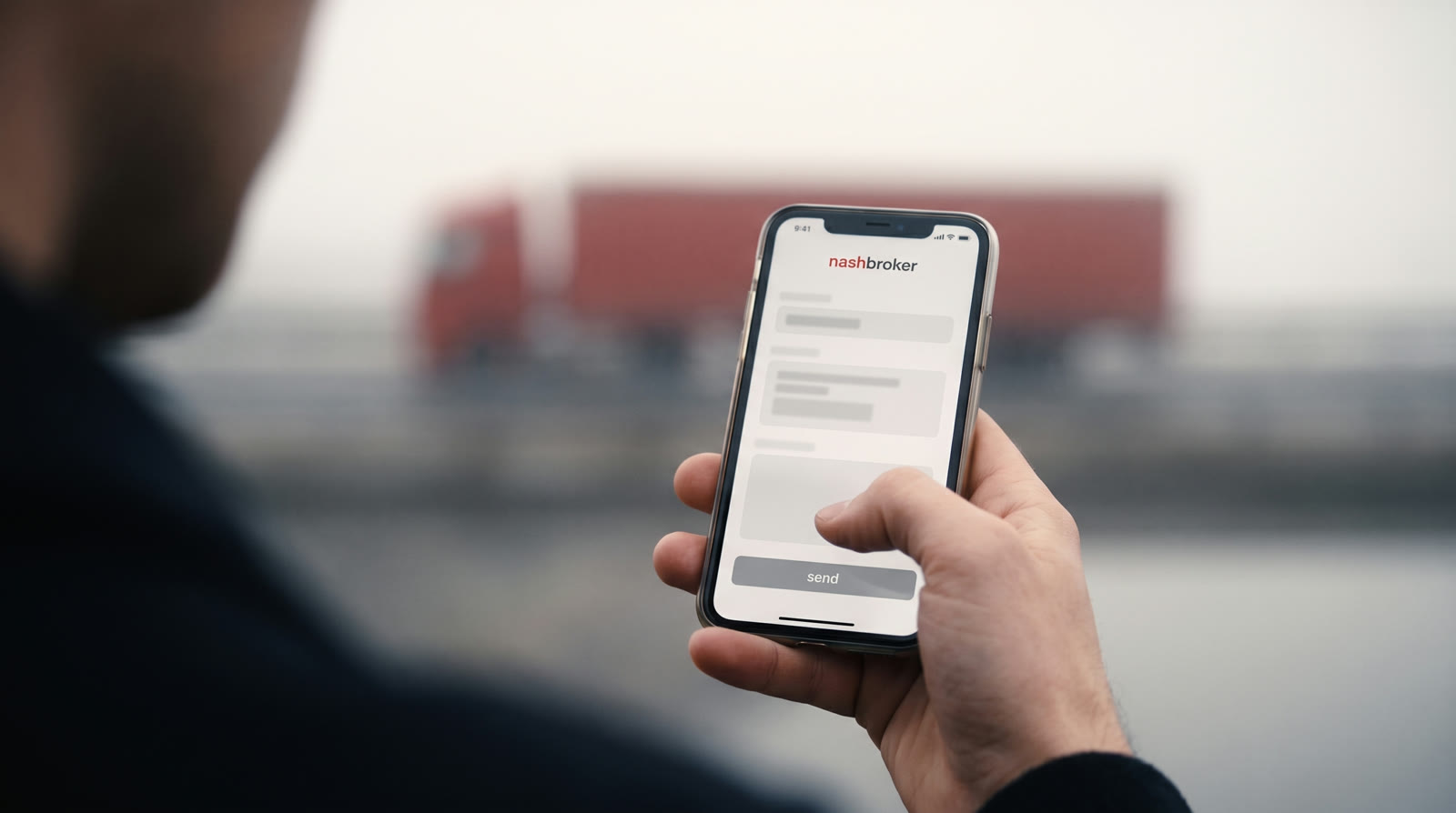 Telefon ekranında NashBroker uygulamasından iş gönderimi; arka planda sisli lojistik tesisi